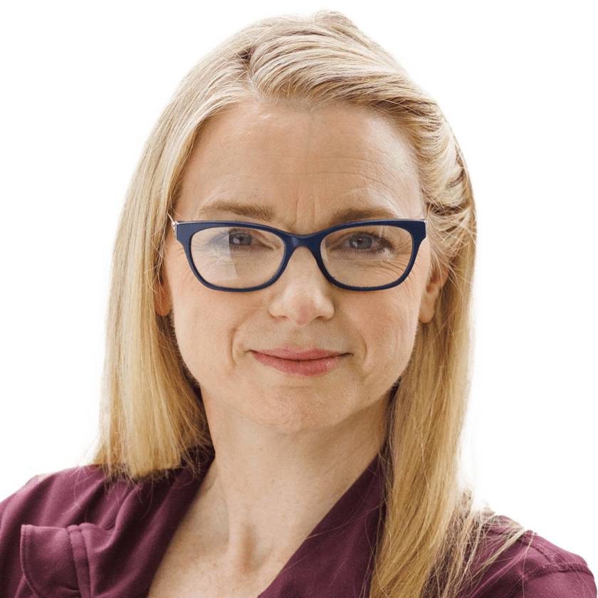 A white woman with long blonde hair and dark glasses is seen from the neck up. She faces the camera with a neutral smile
