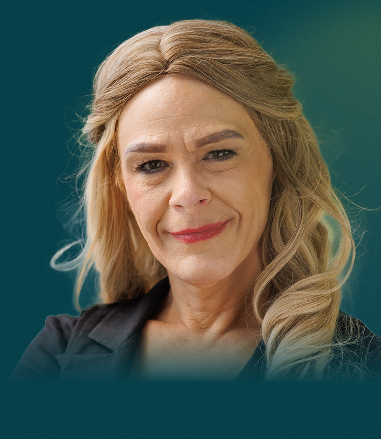 A white woman with long blonde hair faces the camera with a neutral smile