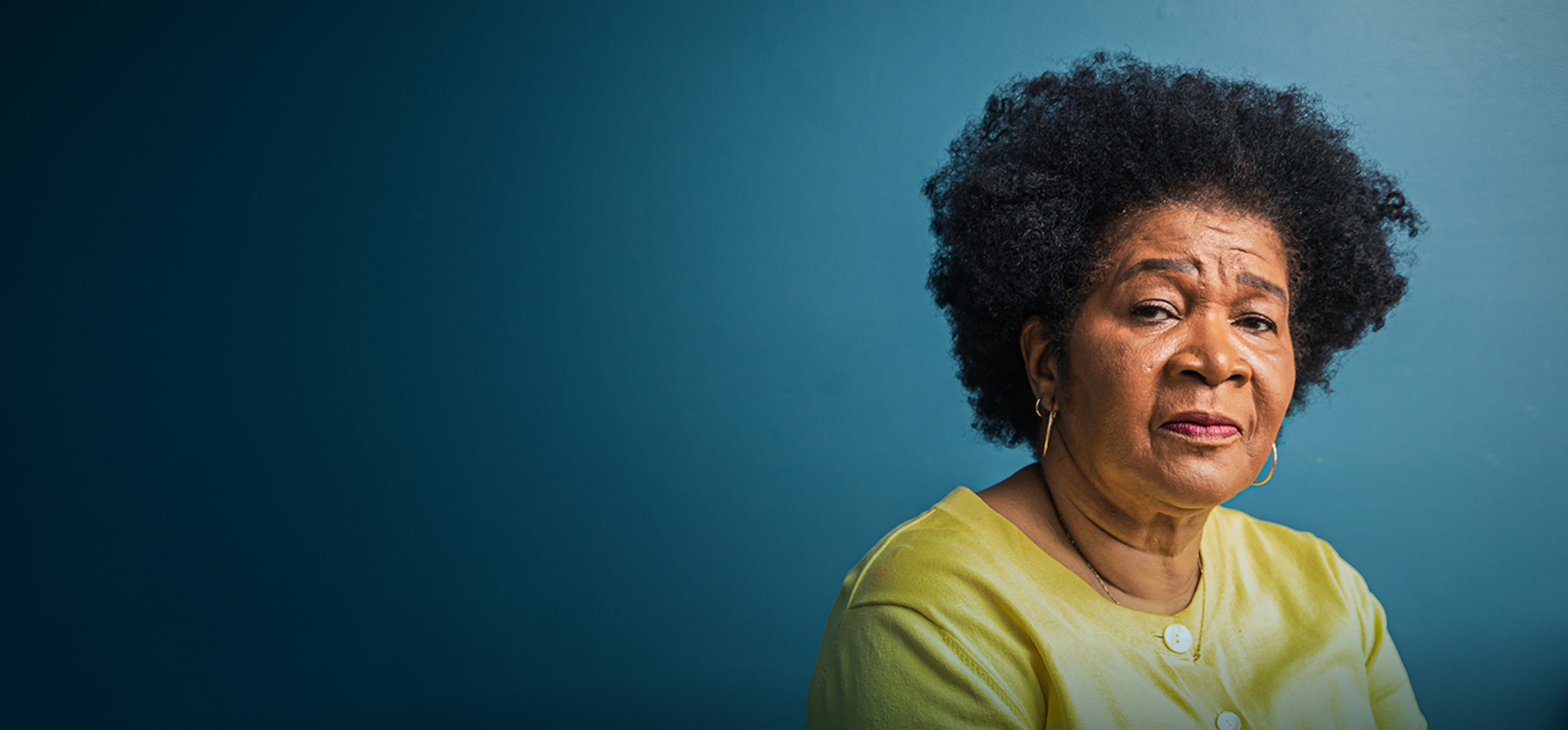 An African-American woman seen from the chest up with a serious expression