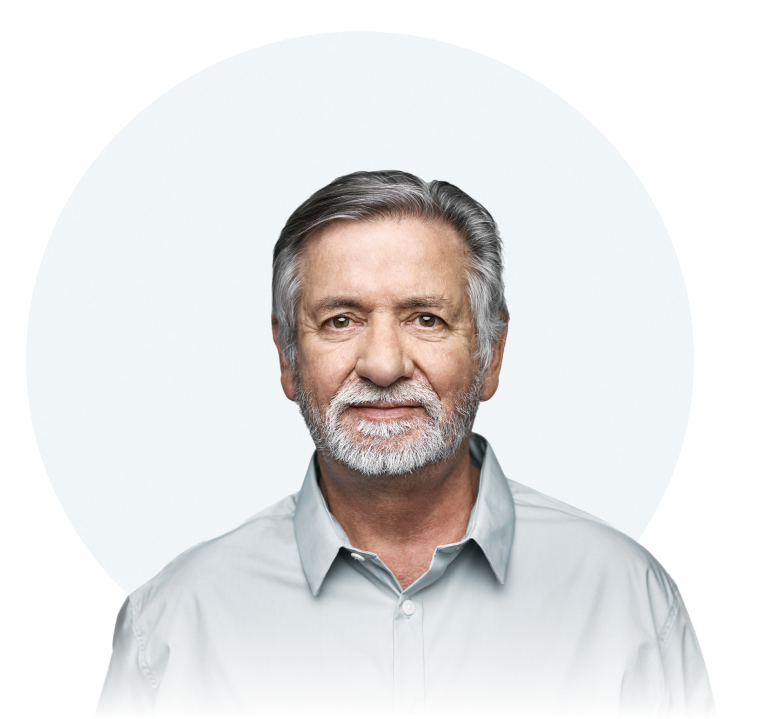 A white man with gray hair and a gray goatee is seen from the chest up. He is looking straight at the camera with a neutral expression.